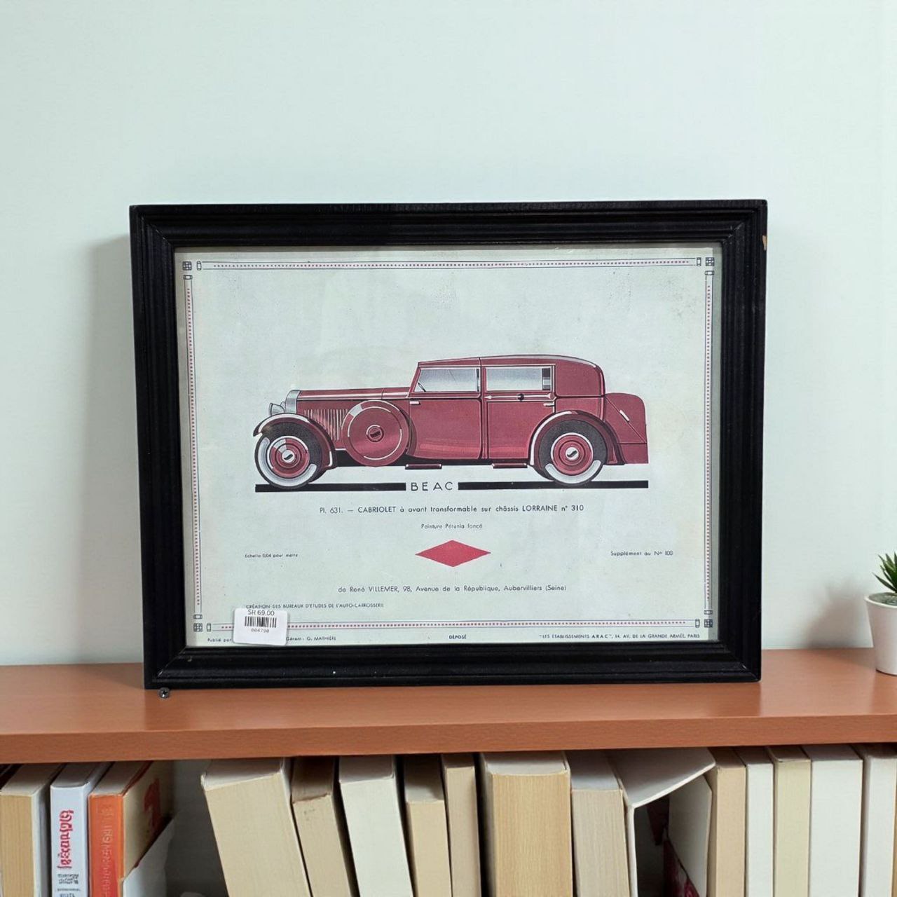 لوحة جدارية بإطار خشبي أسود وصورة سيارة حمراء قديمة – ديكور جداري أنيق للمجالس والمكاتب